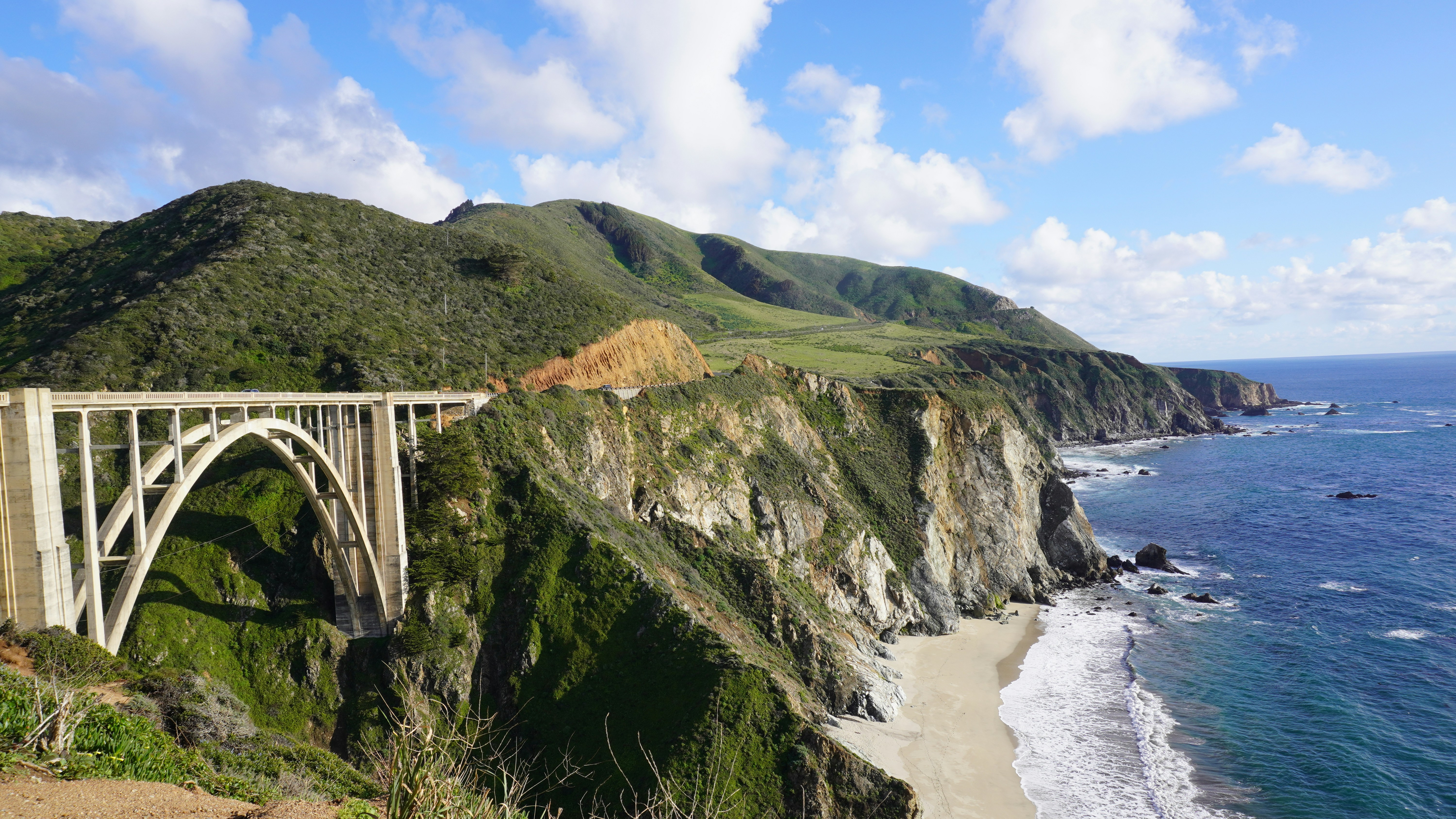 Camper van on Pacific Coast Highway at Big Sur with ocean cliffs and coastal fog
